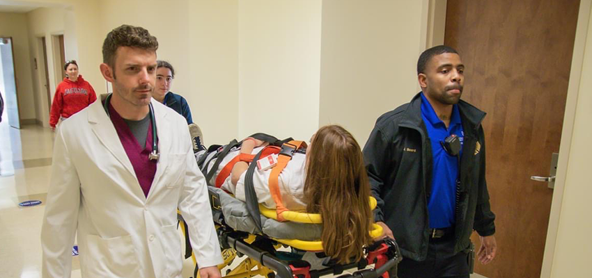 Image of Physician Assistant Studies student looking in another student's ear.