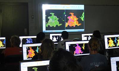 GIS students in class looking at maps.