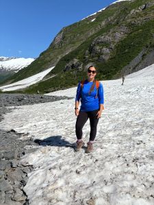woman standing on glacial ice on alaskan mountain