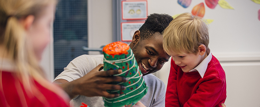 Teacher working with student on art project.