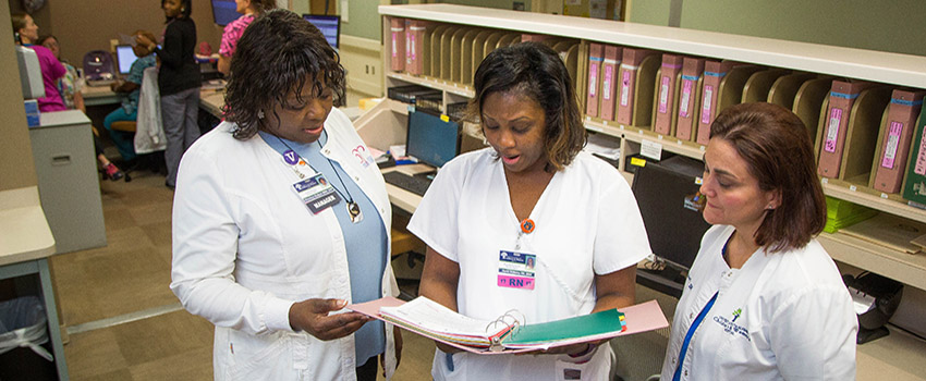 Three nurses reviewing a chart.