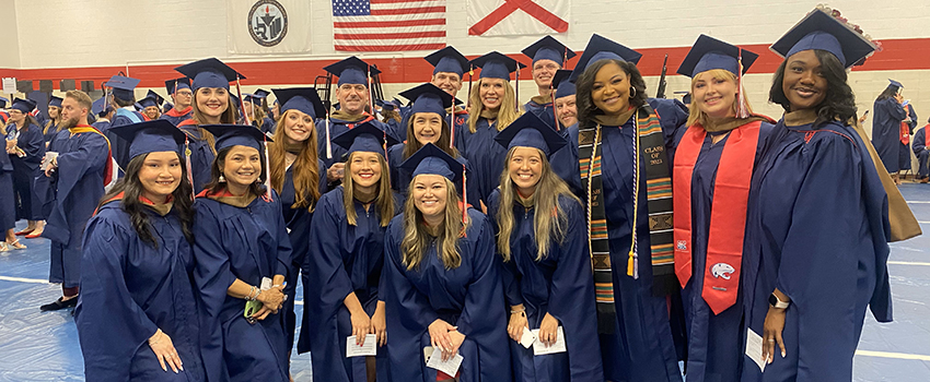 MBA grads in cap and gowns.