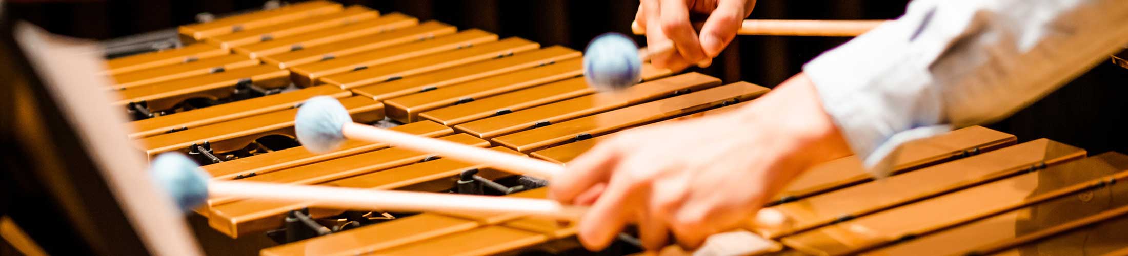 Hands playing on a percussion instrument.