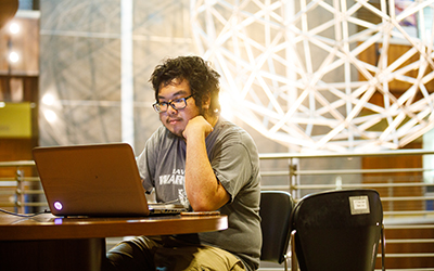 Student Working in lobby on laptop.