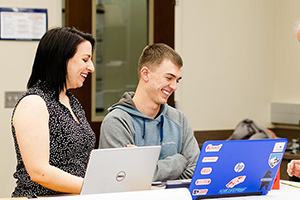 Professor working with student on laptop