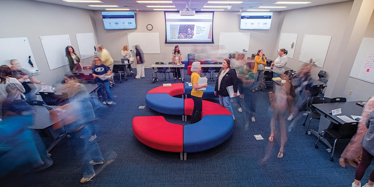 A group of people in a room with monitors and a s shaped seat. data-lightbox='featured'