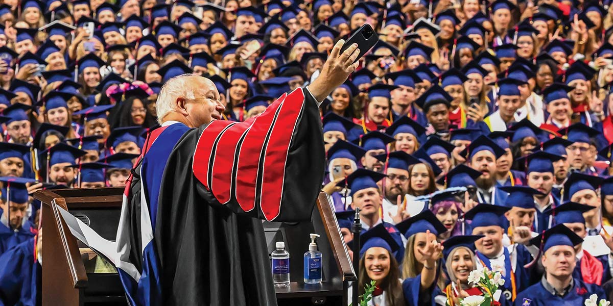President Bonner taking a photo of the graduates at graduation. data-lightbox='featured'