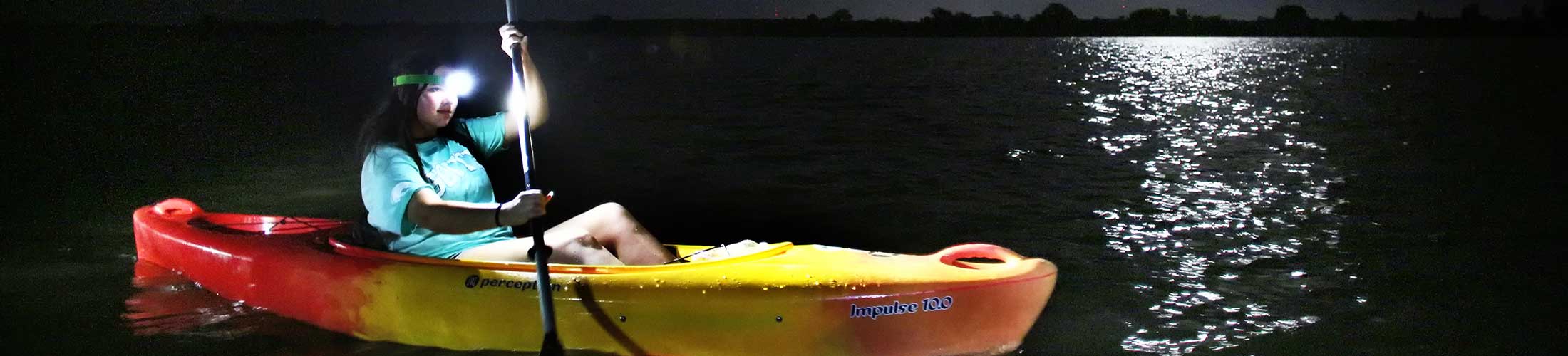 Student on a moon light paddle in a canoe