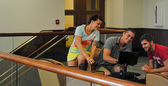 Students looking at a laptop together