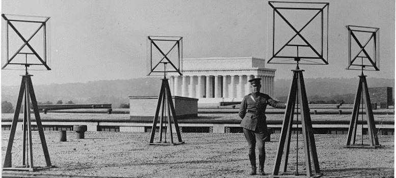 Image of a soldier standing next to radio antenna/satellite radars