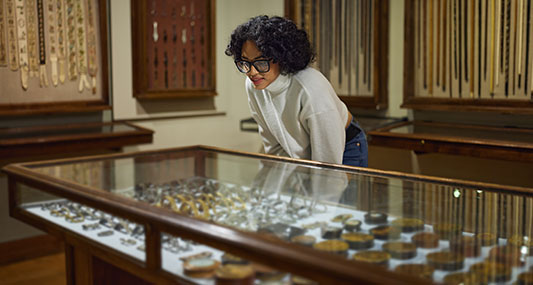 Person looking at art in cases.