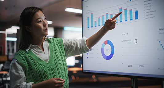 Student pointing to graph on monitor.