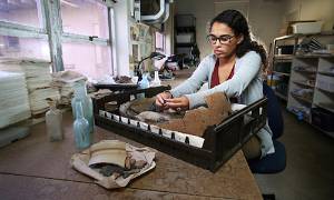 Student working in lab with artifact.