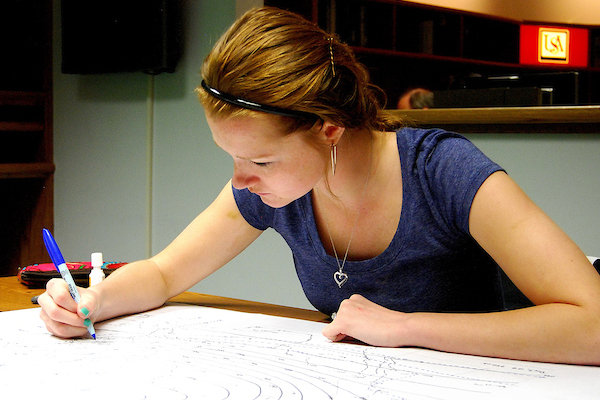 Female working on map.